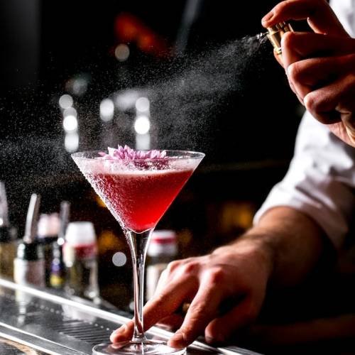 bar-tender-sprays-cocktail-glass