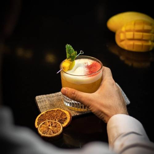 man-holding-cocktail-with-mango